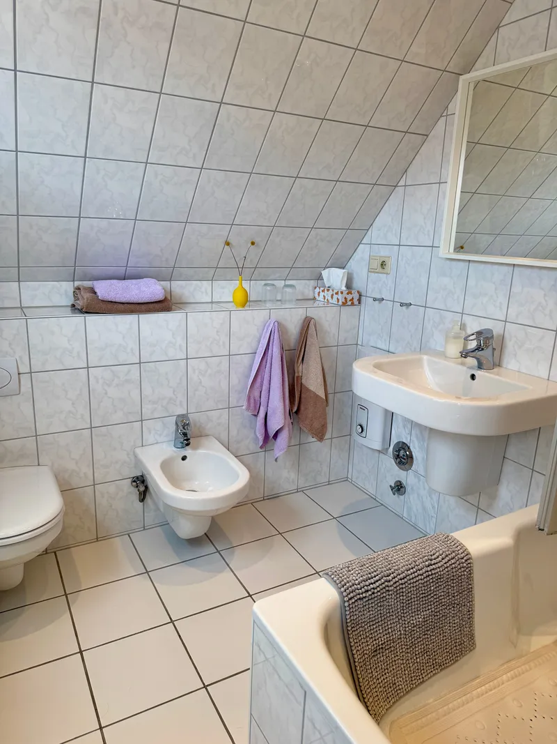 Bad unter der Dachschräge mit Waschbecken, WC, Bidet und Badewanne