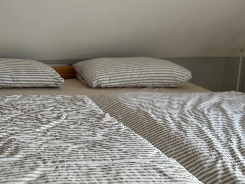 Doppelbett mit gestreifter Bettwäsche
